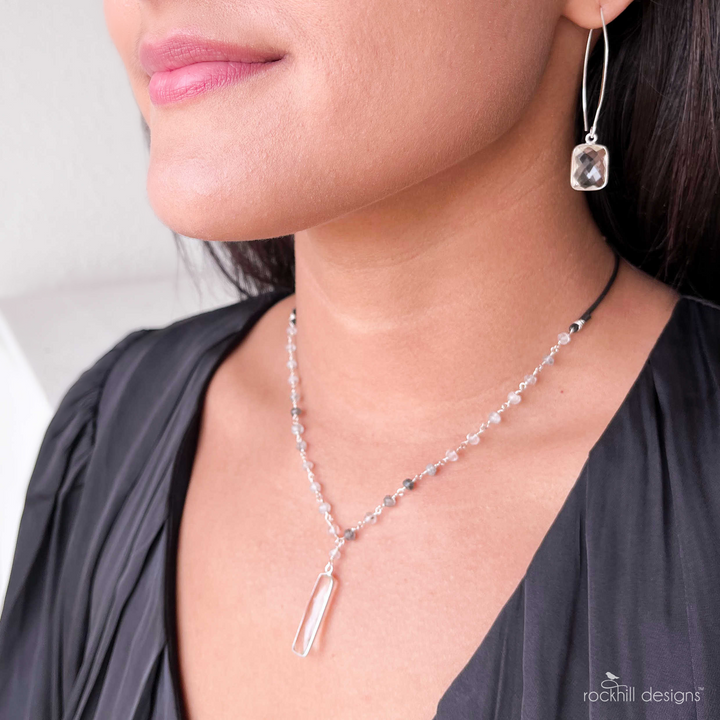 Faceted clear quartz are bezel-set in sterling silver and dangle from long ear wires. Shown on a model. Earrings measure 2 1/4" long.