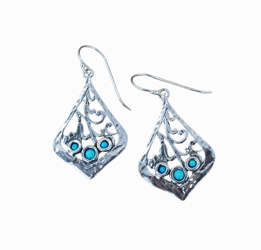 Trio of lab created blue opal is bezel set in each sterling silver earring. They are artisancrafted with scroll details. Dangle from a French ear wire.
