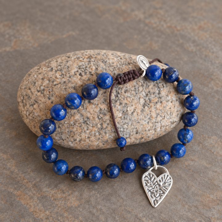 Lovely in Lapis bracelet styled to show the lapis beads, adjustable cord, and sterling silver heart charm.