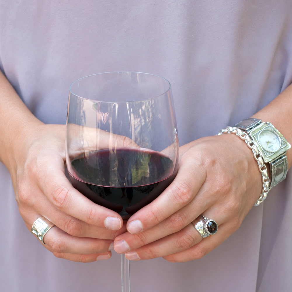 Classic Link Italian sterling silver bracelet worn beside a silver watch as a woman holds a glass of red wine.