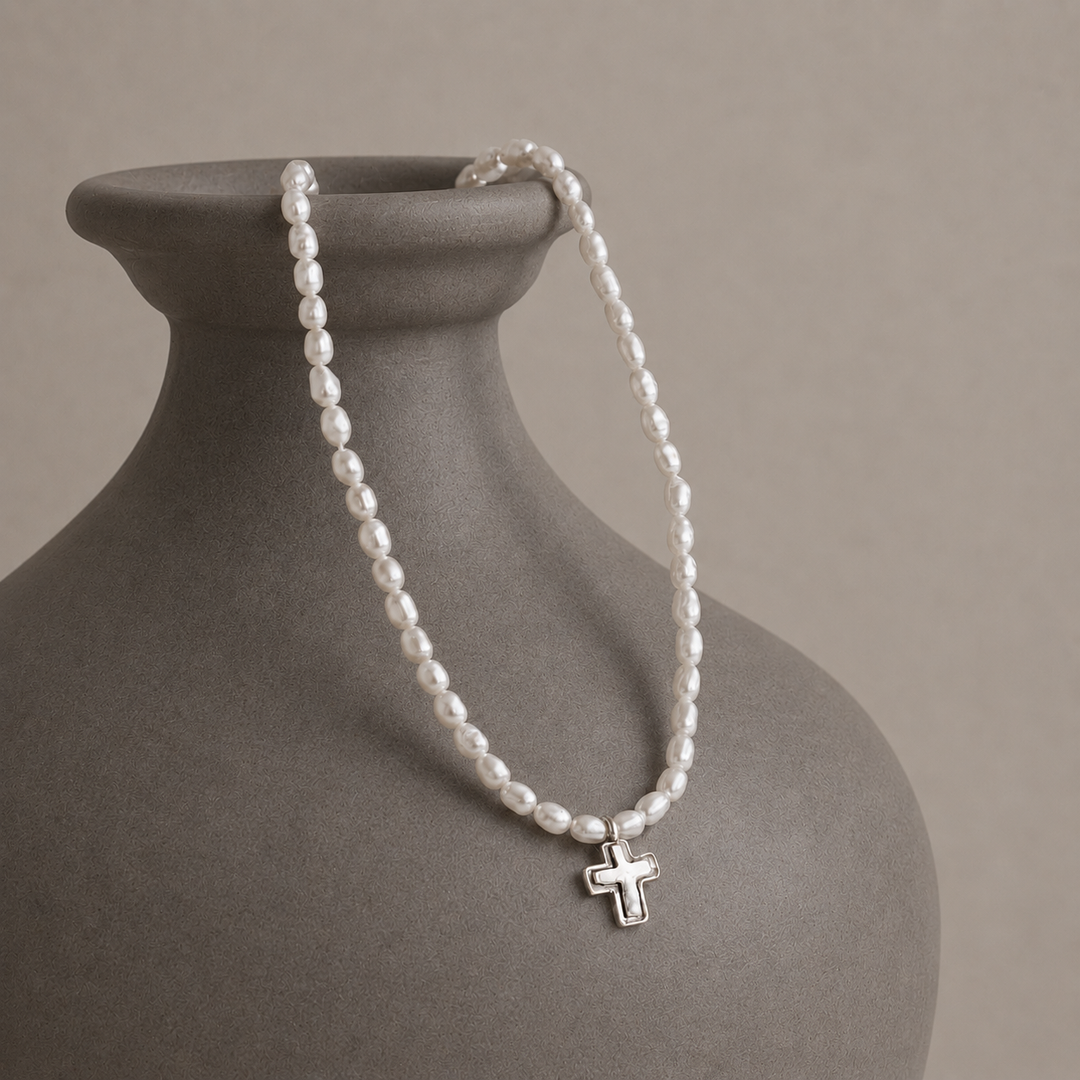 Graceful Cross Necklace with freshwater pearls and sterling silver cross pendant displayed on a grey-brown ceramic vase.