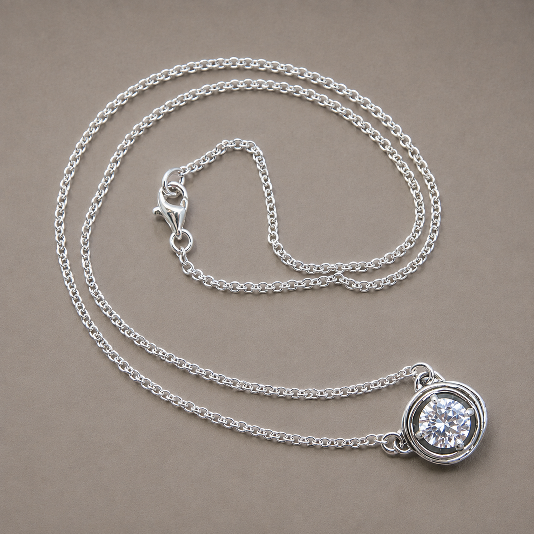 Brilliant sterling silver necklace with a clear CZ solitaire in a sculptural nest-inspired pendant.