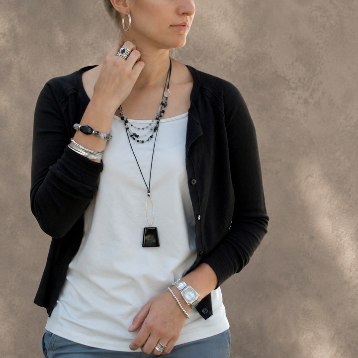 Midnight Harmony black agate and black rutilated quartz necklace with sterling silver and black leather worn on a model.