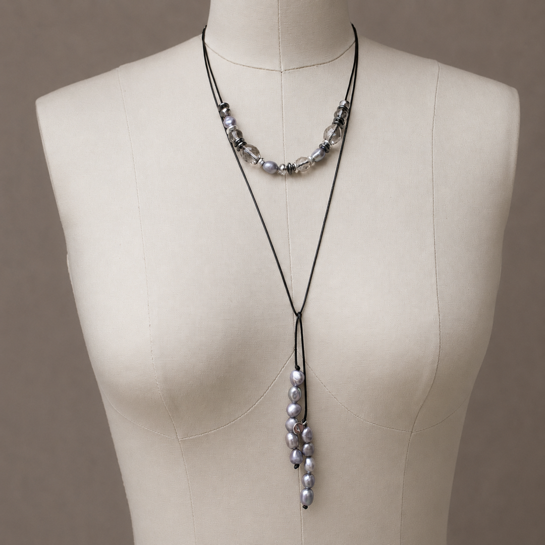 Northern Lights lariat necklace with gray freshwater pearls, hematite, and crystal accents displayed on an off white jewelry bust.