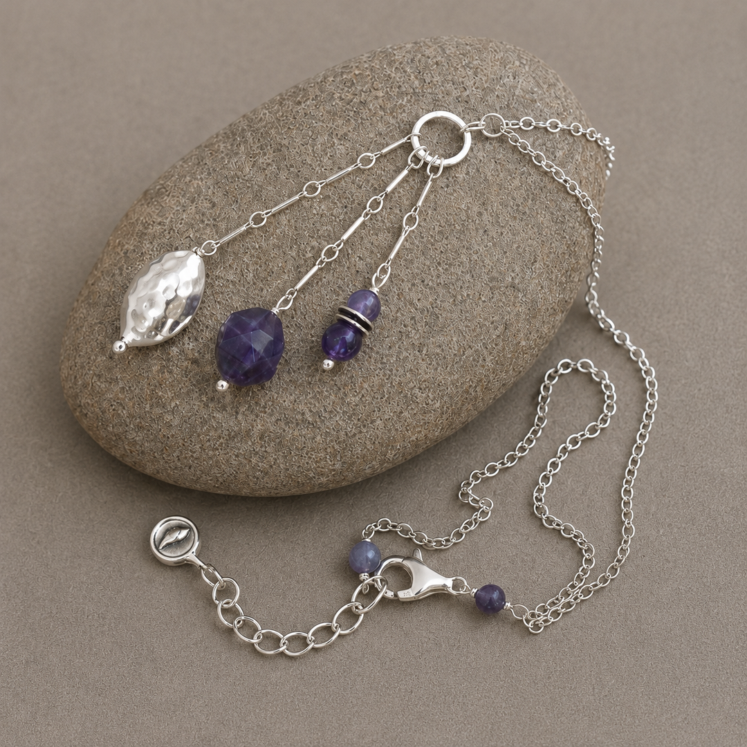 Royal Trio Necklace with silver and amethyst bead drop pendant displayed on a smooth stone.