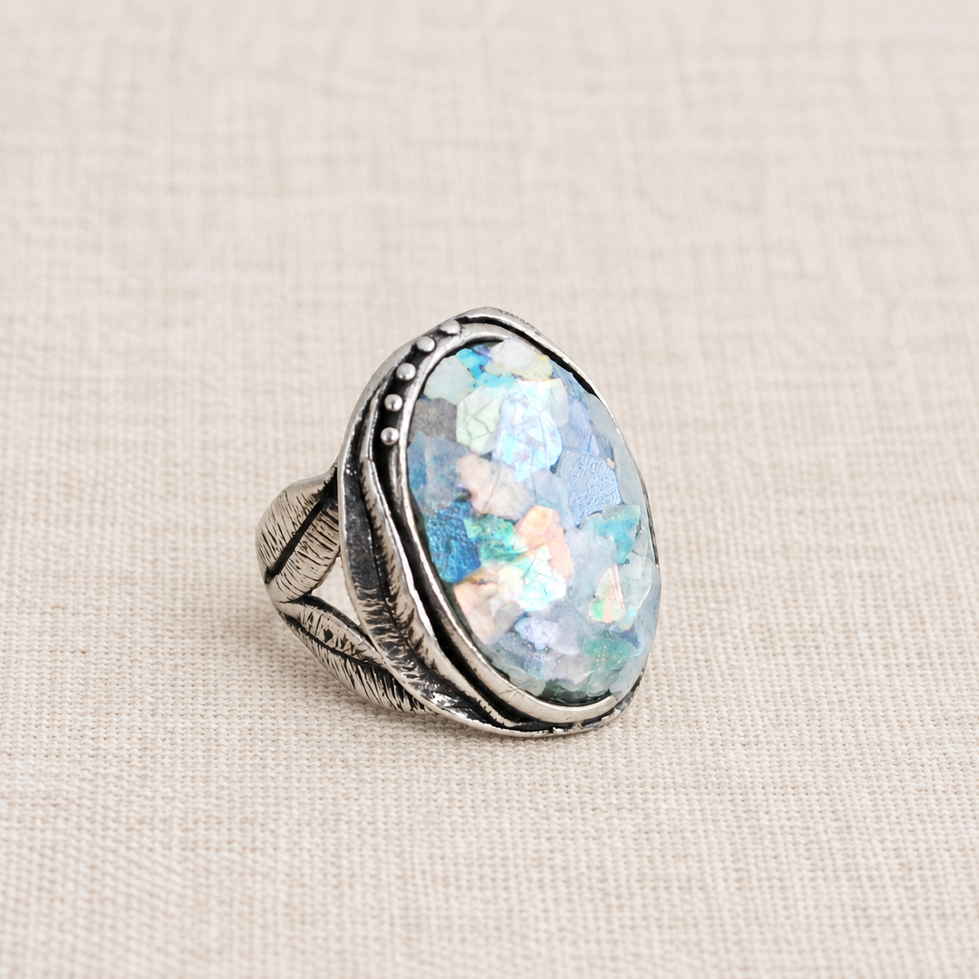 Pamona sterling silver ring with an oval composite Roman glass cabochon showing aqua, pink, and purple iridescence.