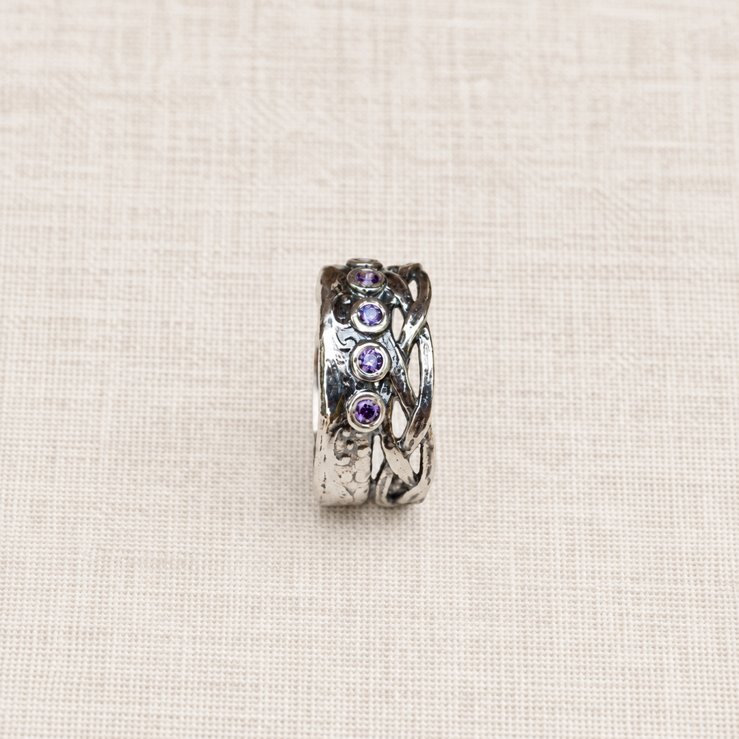 Side view of the Royalty sterling silver ring showing the bezel-set purple CZ stones and textured band.