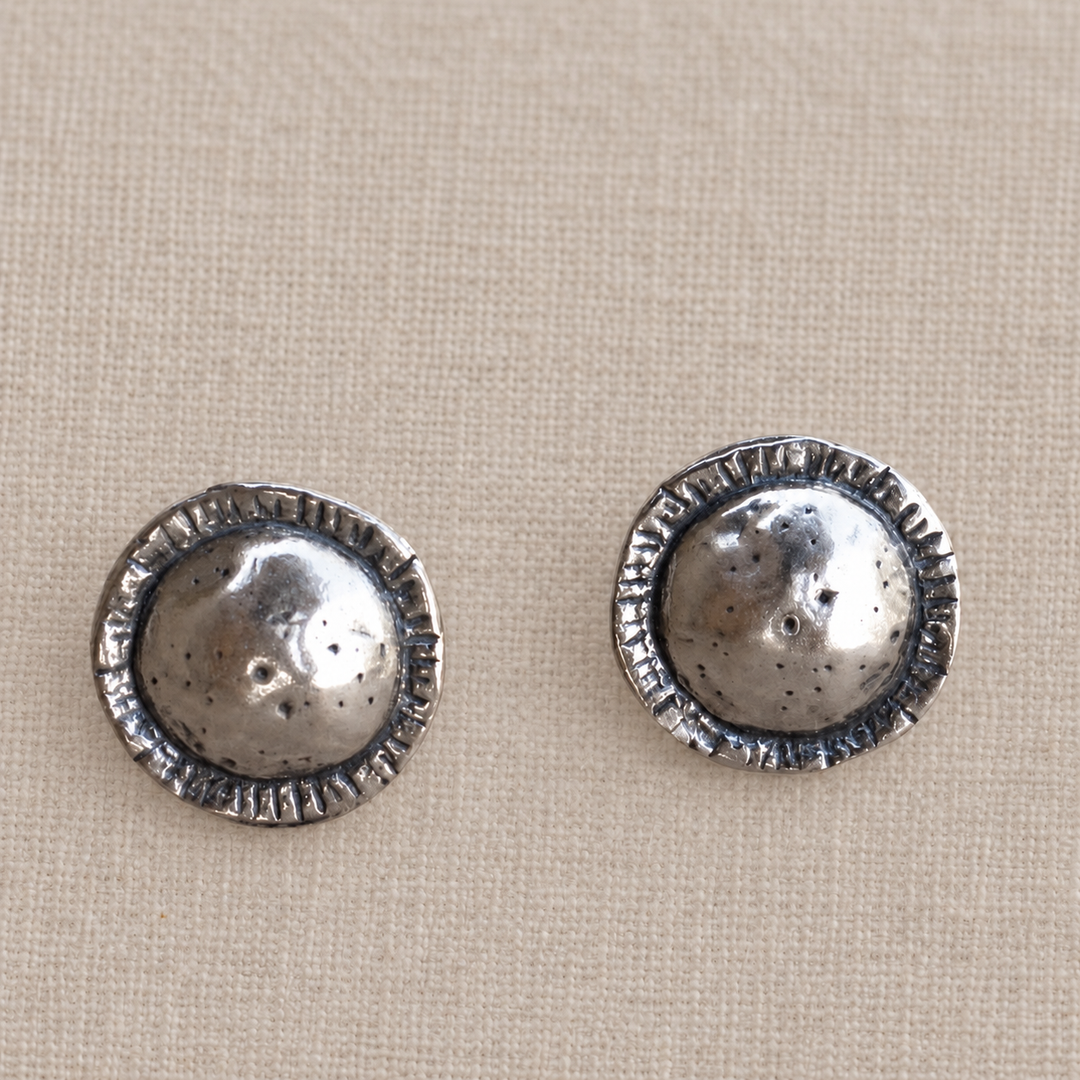 Front view of On Point sterling silver studs showing the hammered, lightly oxidized texture and etched edges.