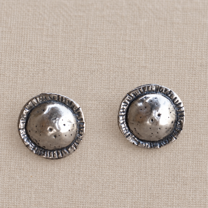 Front view of On Point sterling silver studs showing the hammered, lightly oxidized texture and etched edges.