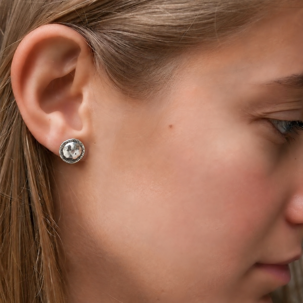 Model wearing On Point hammered sterling silver stud earrings to show scale.