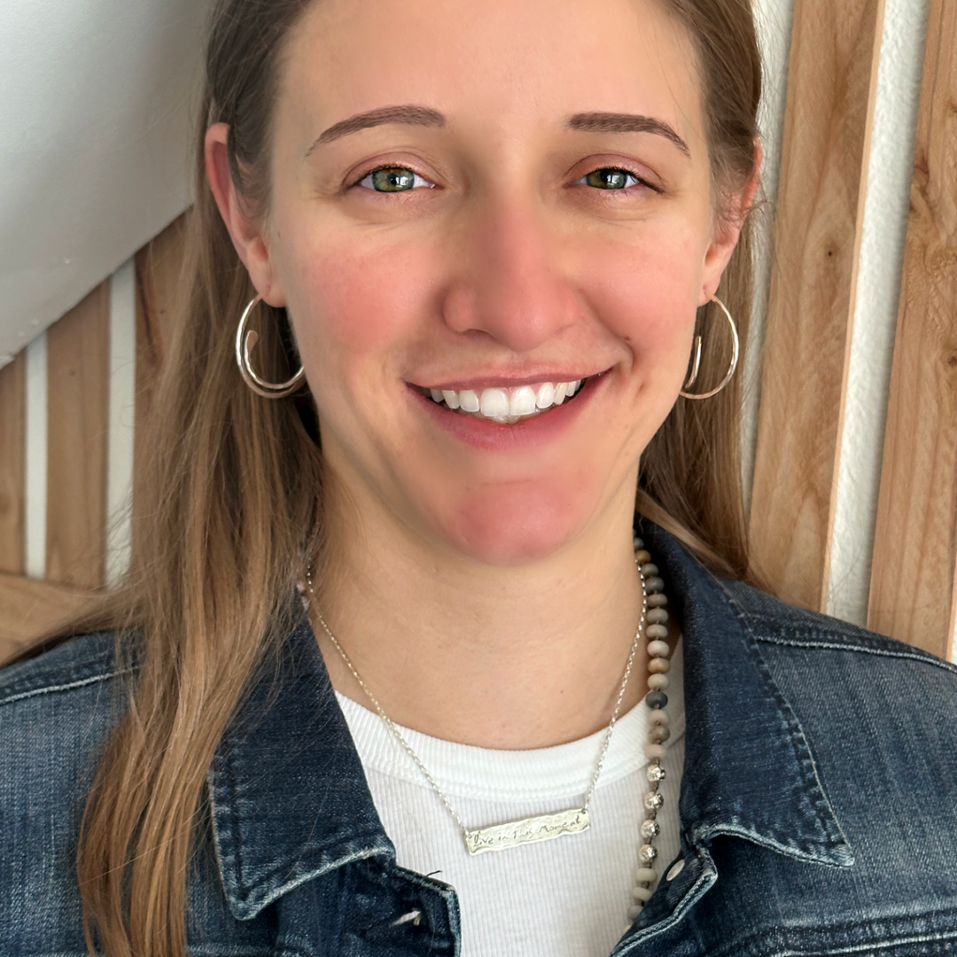 A pair of sterling silver hoop earrings with a hammered finish, shown on a model.