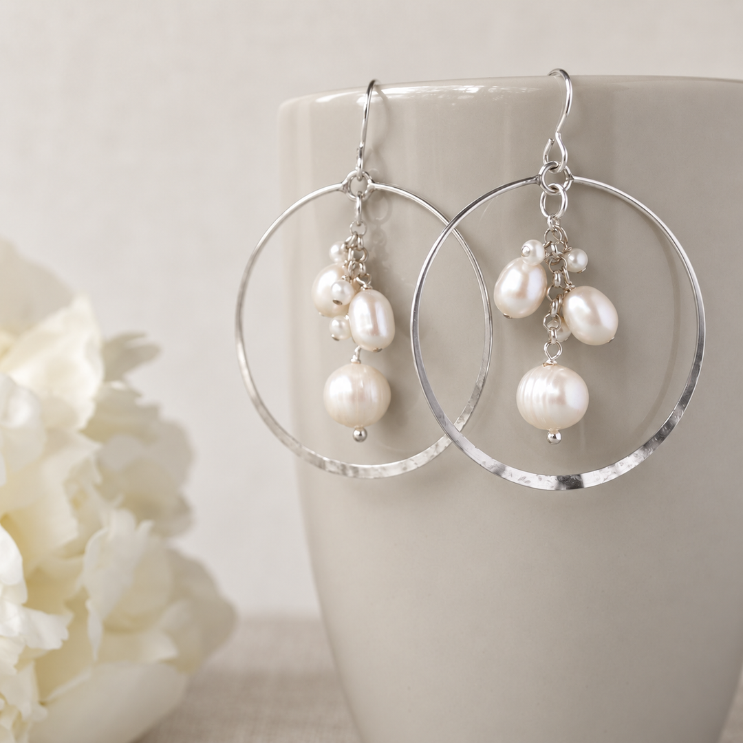 Pearl Party Freshwater Pearl & Sterling Silver Earrings with softly white pearl clusters displayed on a cream ceramic cup against a warm neutral background.