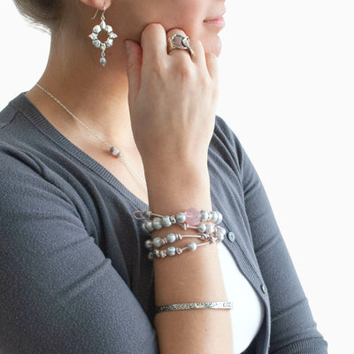 Stretch Bracelet- grey freshwater pearls with a faceted chunk of rose quartz and silver accent beads. Shown on a Model. RockHill Exclusive.