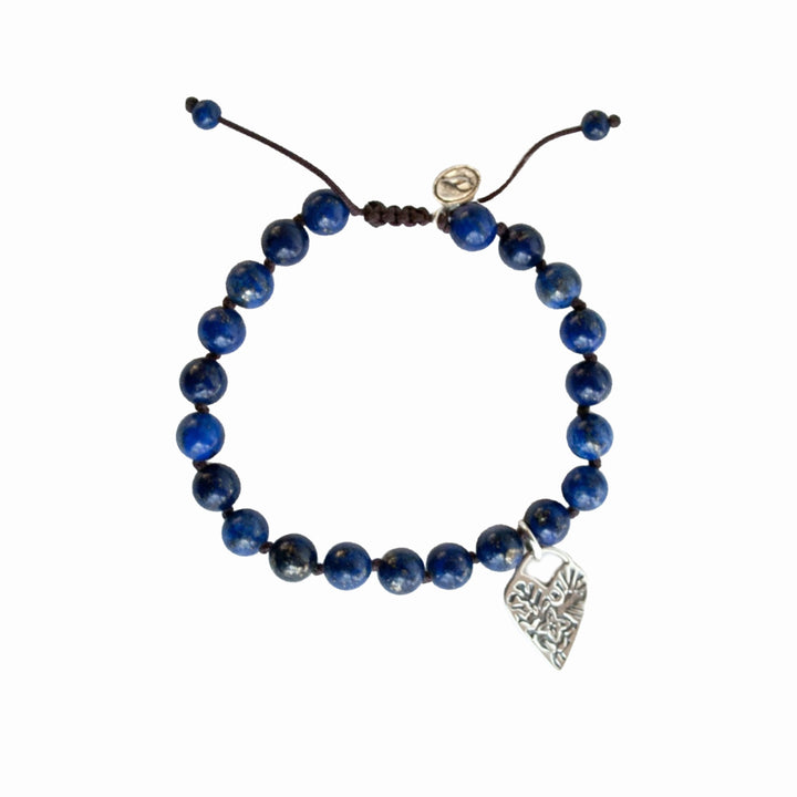 Bracelet consisting of smooth round 1/4" lapis beads on a brown adjustable silk cord. Features a heart dangle.