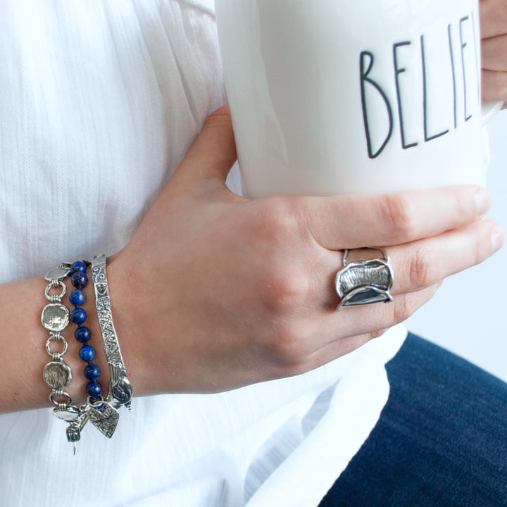 A sterling silver link bracelet with a textured finish and an adjustable toggle closure. Shown on a model.
