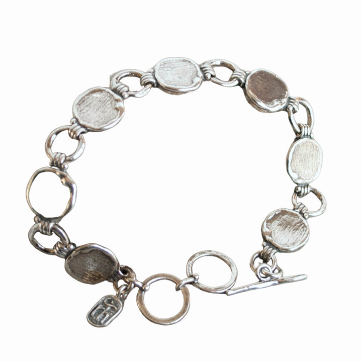 A sterling silver link bracelet with a textured finish and an adjustable toggle closure.