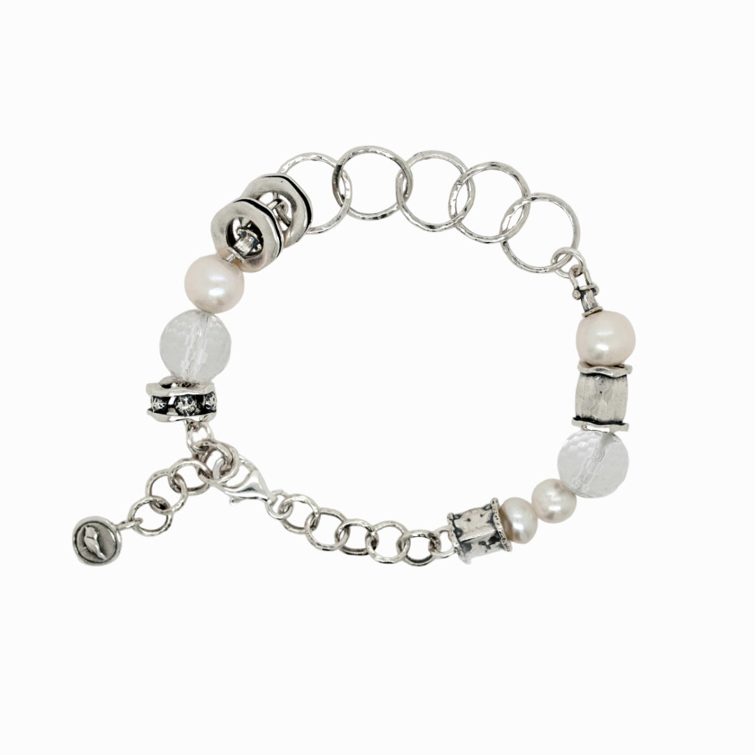 A sterling silver link bracelet with white freshwater pearls, faceted clear quartz, and silver accents is shown on a white background. 