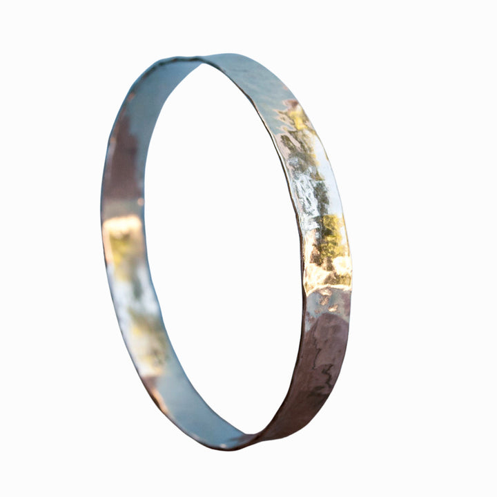 Hammered sterling silver bangle bracelet shown on a white background.