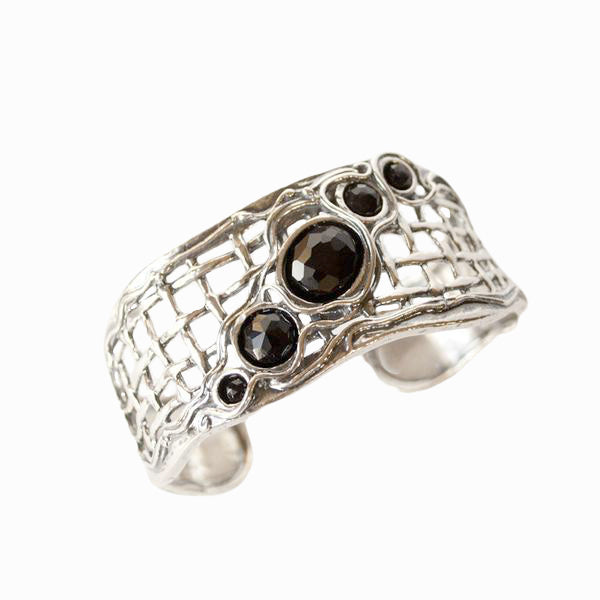 Sterling Silver Cuff Bracelet with faceted black onyx cabochons. Shown on a white background, top of bracelet shown.
