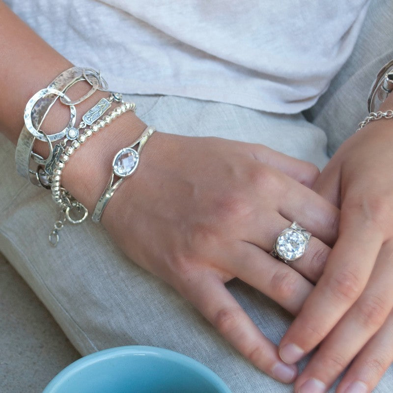 Silver Bracelet with beautiful oval faceted clear CZ. Cuff style bracelet with a safety chain. Artisan-crafted sterling silver bracelet. Shown on a model.