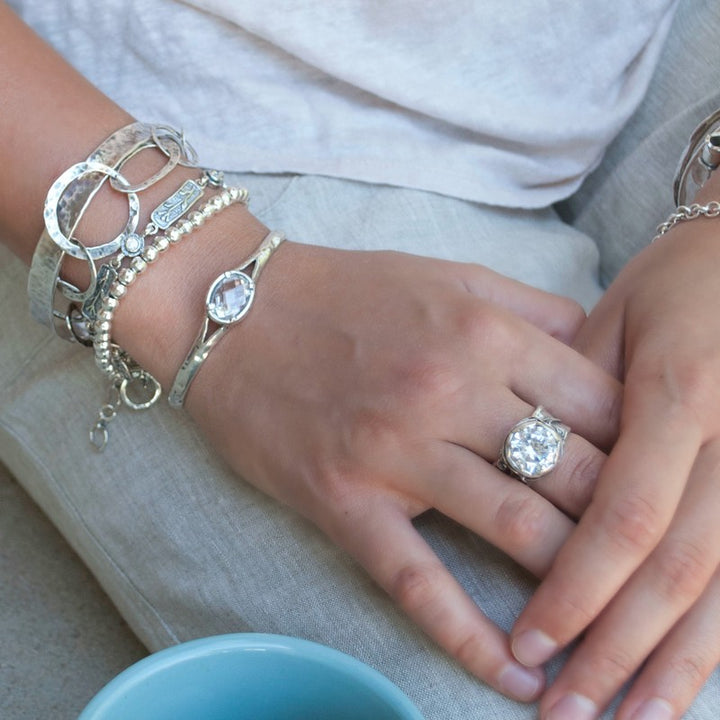 Silver Bracelet with a beautiful oval faceted clear CZ. Cuff-style bracelet with a safety chain. Artisan-crafted sterling silver bracelet. Shown on a model.