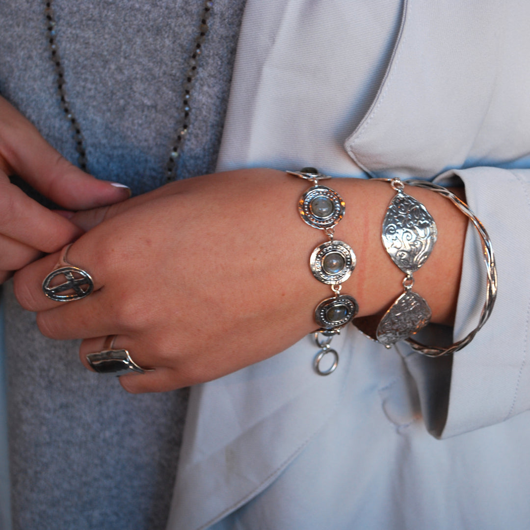 A bracelet with Labradorite cabochons,  set in sterling silver frames, connected by sterling silver links, with an adjustable toggle closure. Shown on a model. 