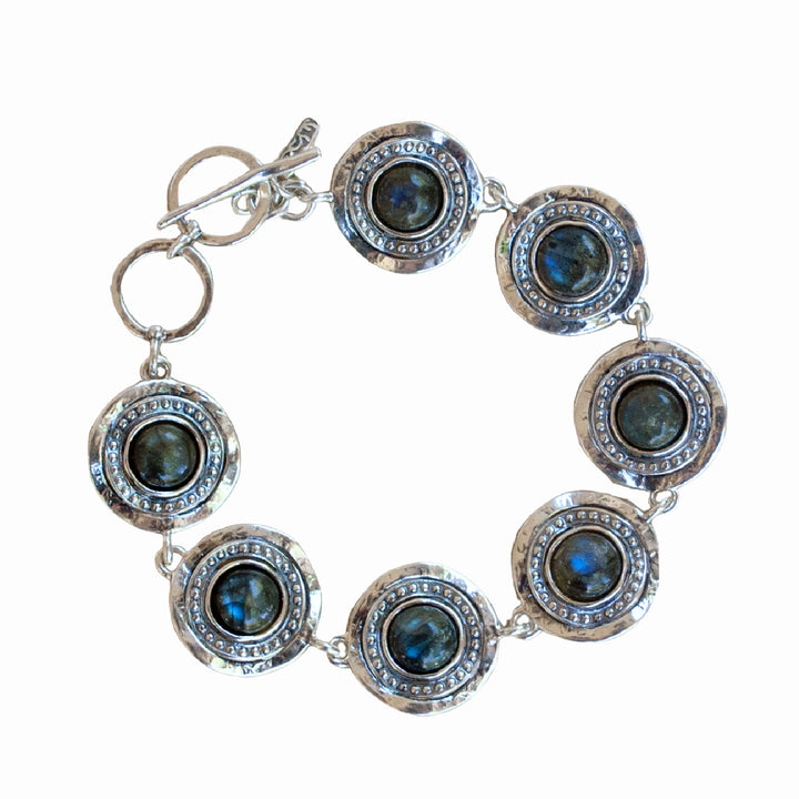 A bracelet with Labradorite cabochons,  set in sterling silver frames, connected by sterling silver links, with an adjustable toggle closure. Shown from above on a white background. 