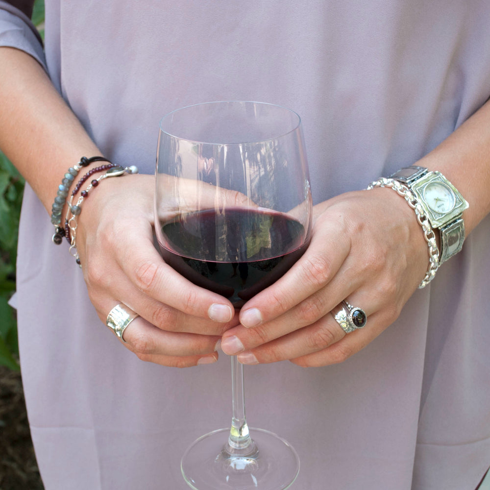 A sterling silver chain link design bracelet with a lobster clasp closure. Shown on a model. 