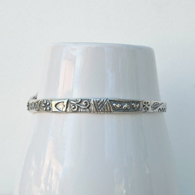 Bangle Bracelet- artisan crafted of .925 sterling silver featuring a bird with textured patterns. Back  of Bracelet shown.