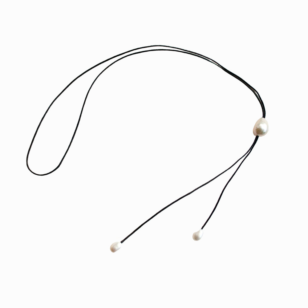 A white freshwater pearl on black cord necklace displayed on a white background.