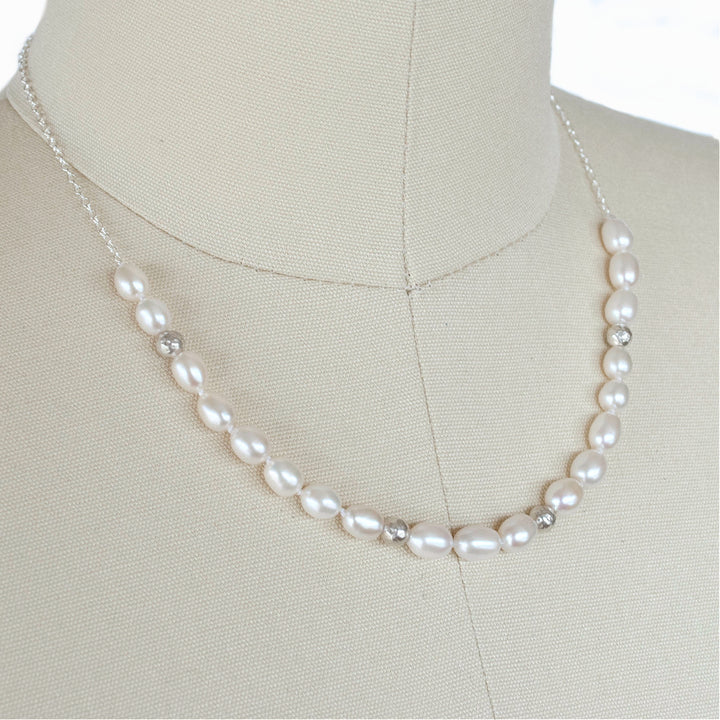 Pearl with Sterling accent beads necklace is shown on a dress from.