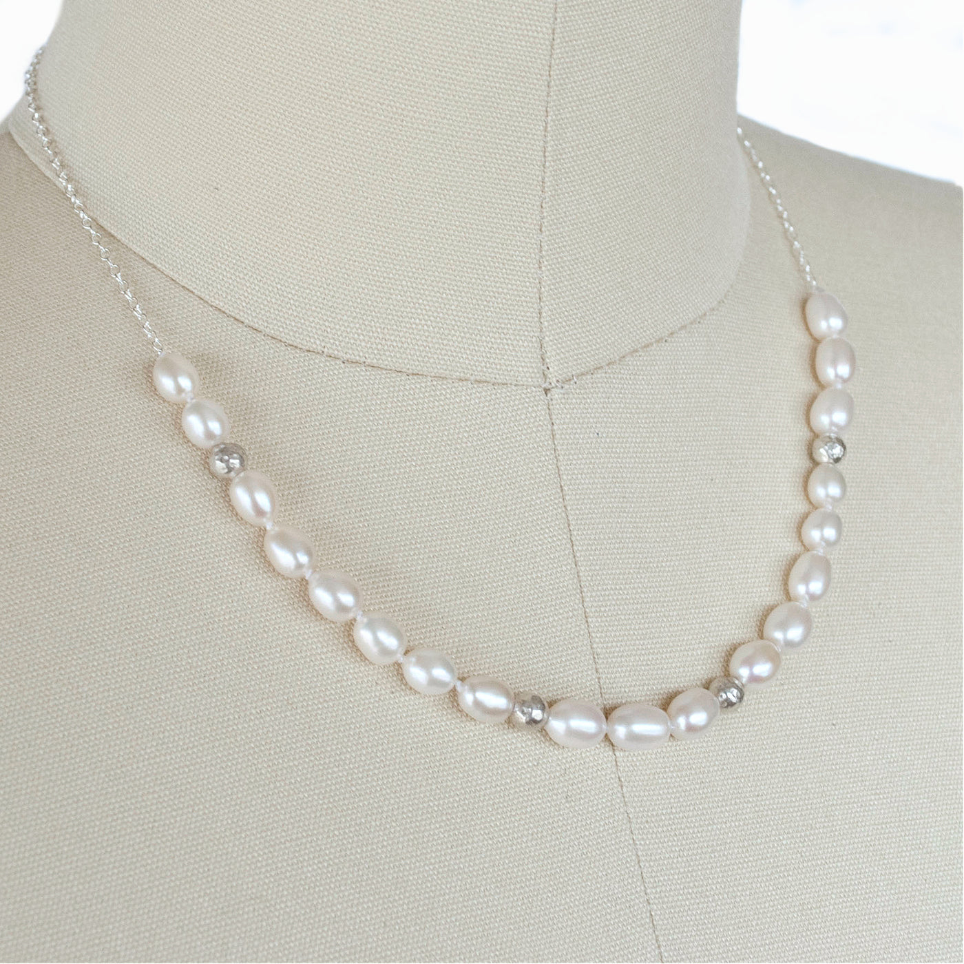 Pearl with Sterling accent beads necklace is shown on a dress from.