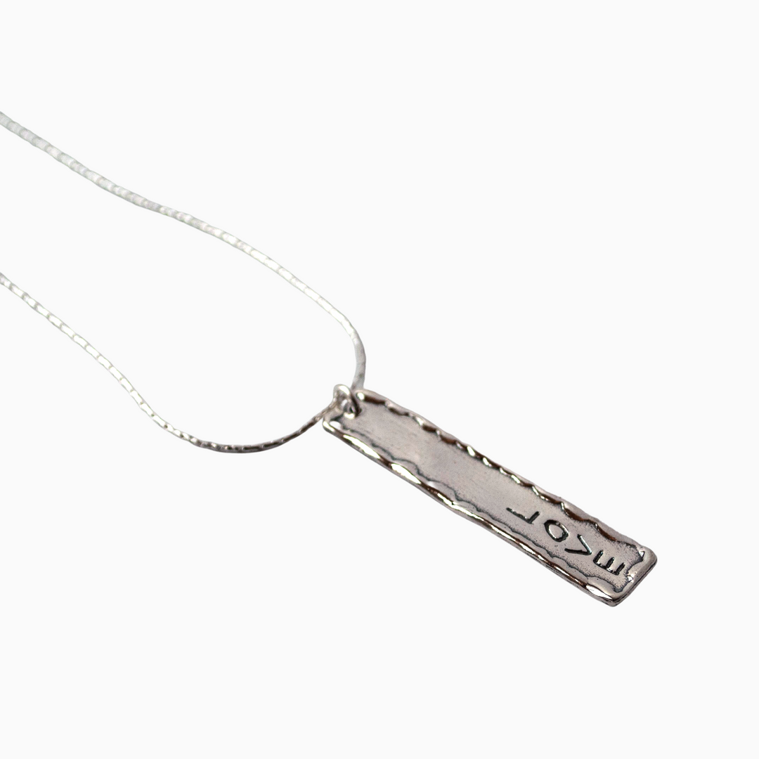 A sterling silver necklace with a polished pendant hallmarked with 'love' and a lobster clasp.