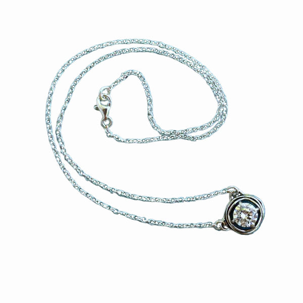 A sterling silver necklace with a centered clear CZ link is shown on a white background. 