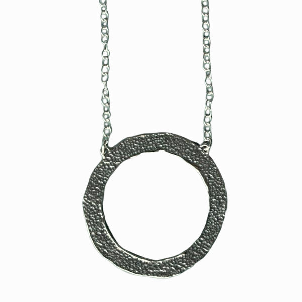 The back of the circle is shown as a close-up on a white background. Shows that the necklace is reversible. 