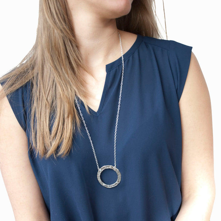 The long sterling isilver circle is shown is shown on a model against a white background. 