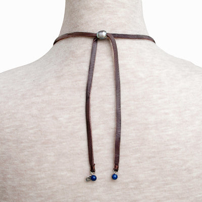 Leather Necklace- Artisan-crafted and handknotted with lapis, grey freshwater pearl and genuine leather. The back is shown with a pearl adjustable slider bead. 
