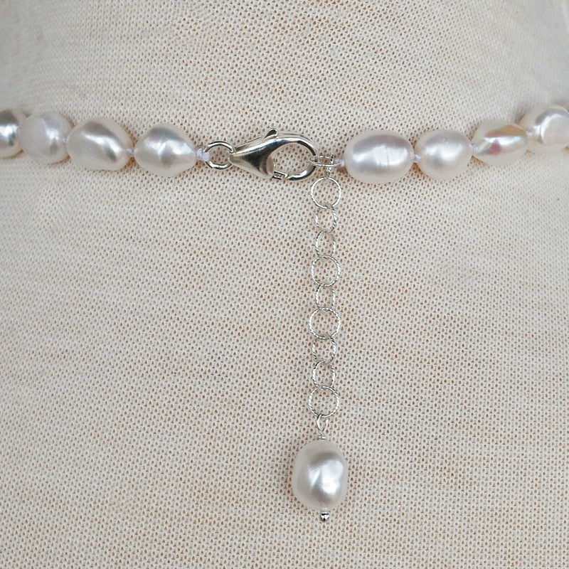 Back view of pearl neckalce is shown with its sterling silver lobster clasp and extender with pearl dangle finishing piece. 