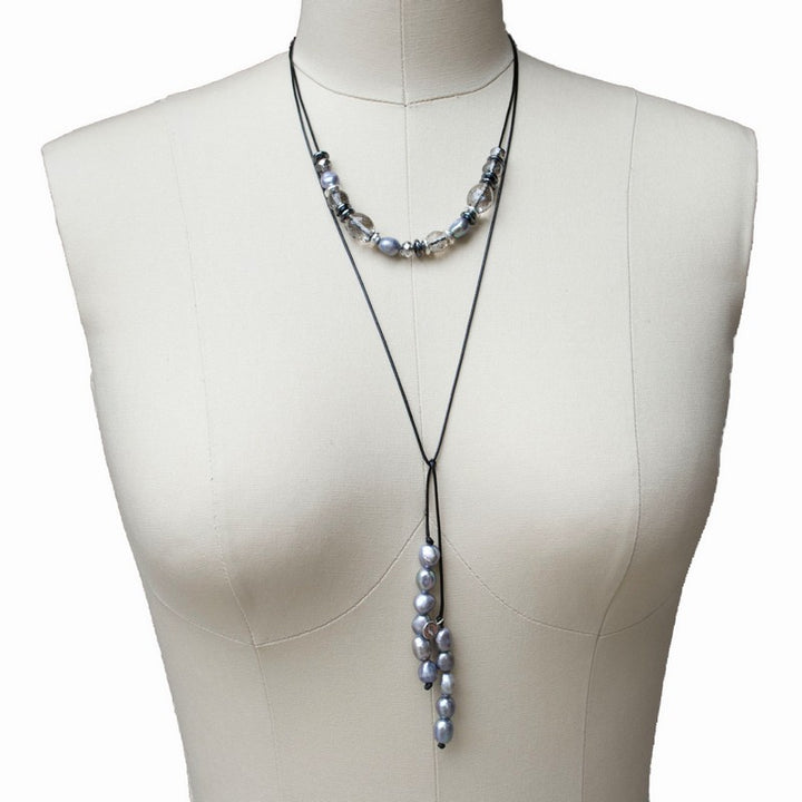 A lariat necklace with gray freshwater pearls, hematite, and crystal, displayed on a mannequin.