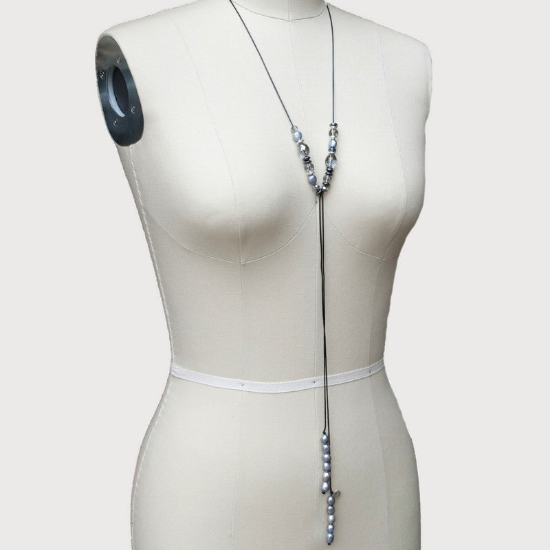 A lariat necklace with gray freshwater pearls, hematite, and crystal, displayed on a mannequin.