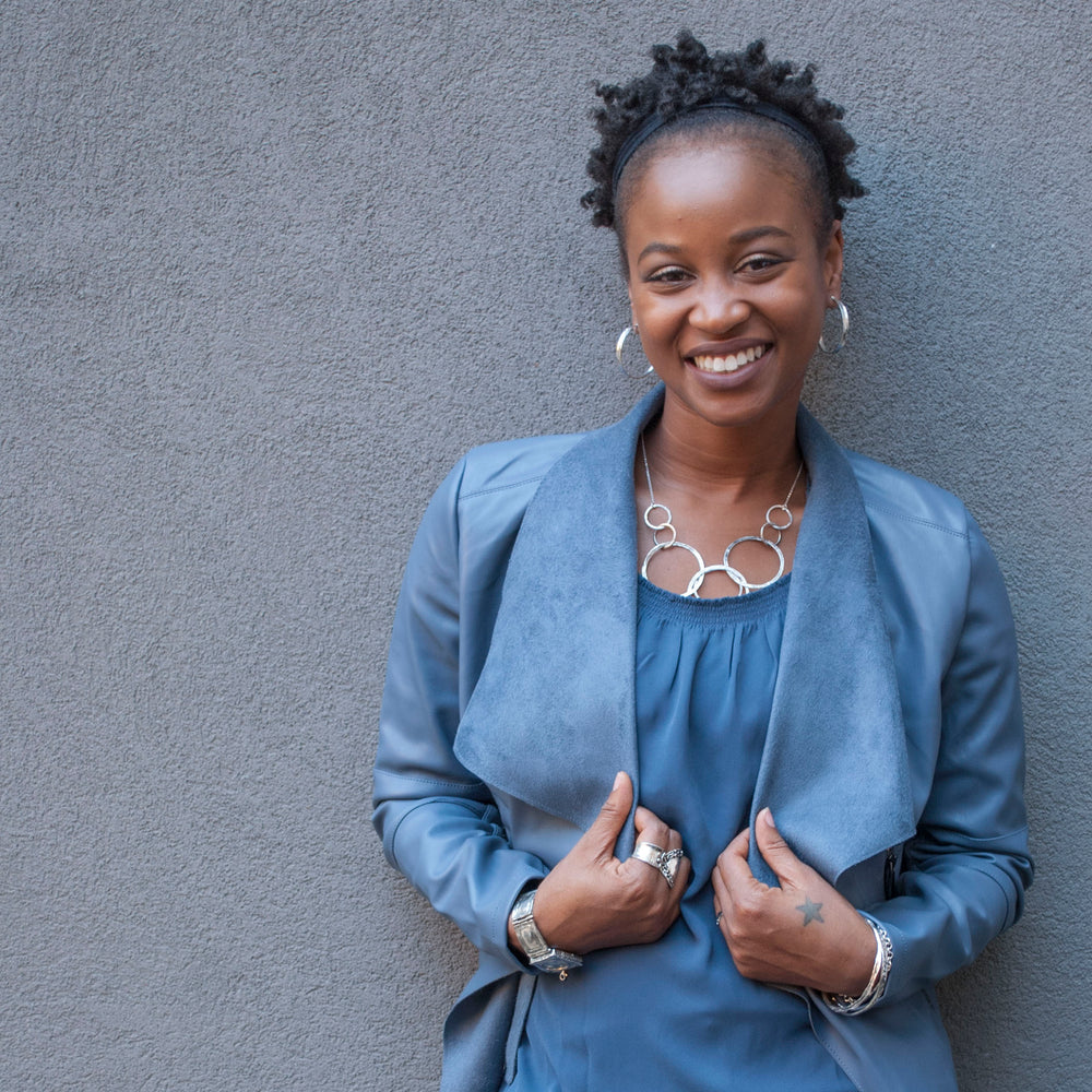 Silver Necklace shown on a model. Necklace features 8 circular links in various sizes and textures. 