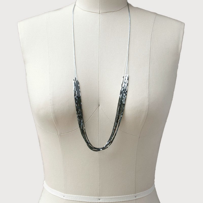 A mannequin displays wearing a silver-colored multi-strand hematite necklace with silk blend cords.
