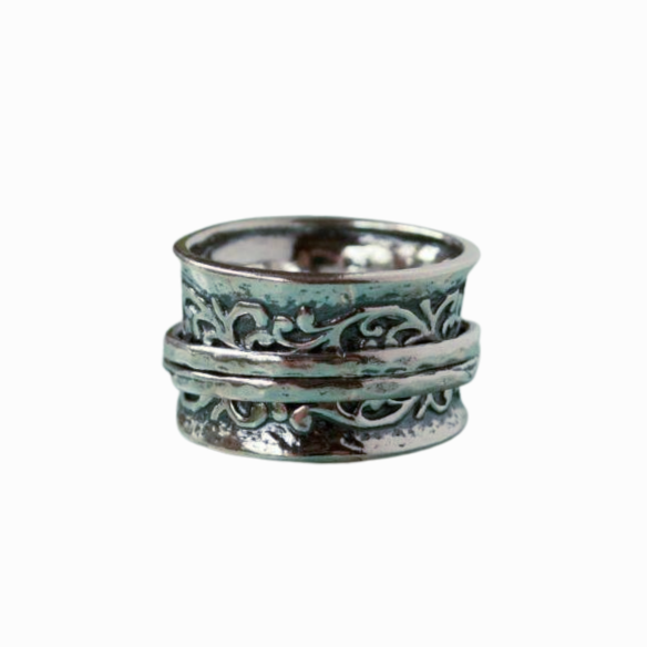 A silver spinner ring with an intricate scroll pattern on a white background.