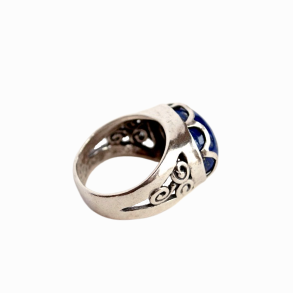 A sterling silver ring with a raised cross design on a curved band, featuring lined details. Side view of details shown.