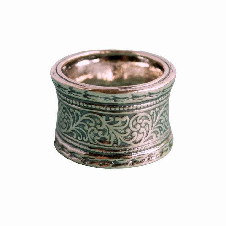 A sterling silver ring with hand-cast vines design, showing intricate patterns around its band.