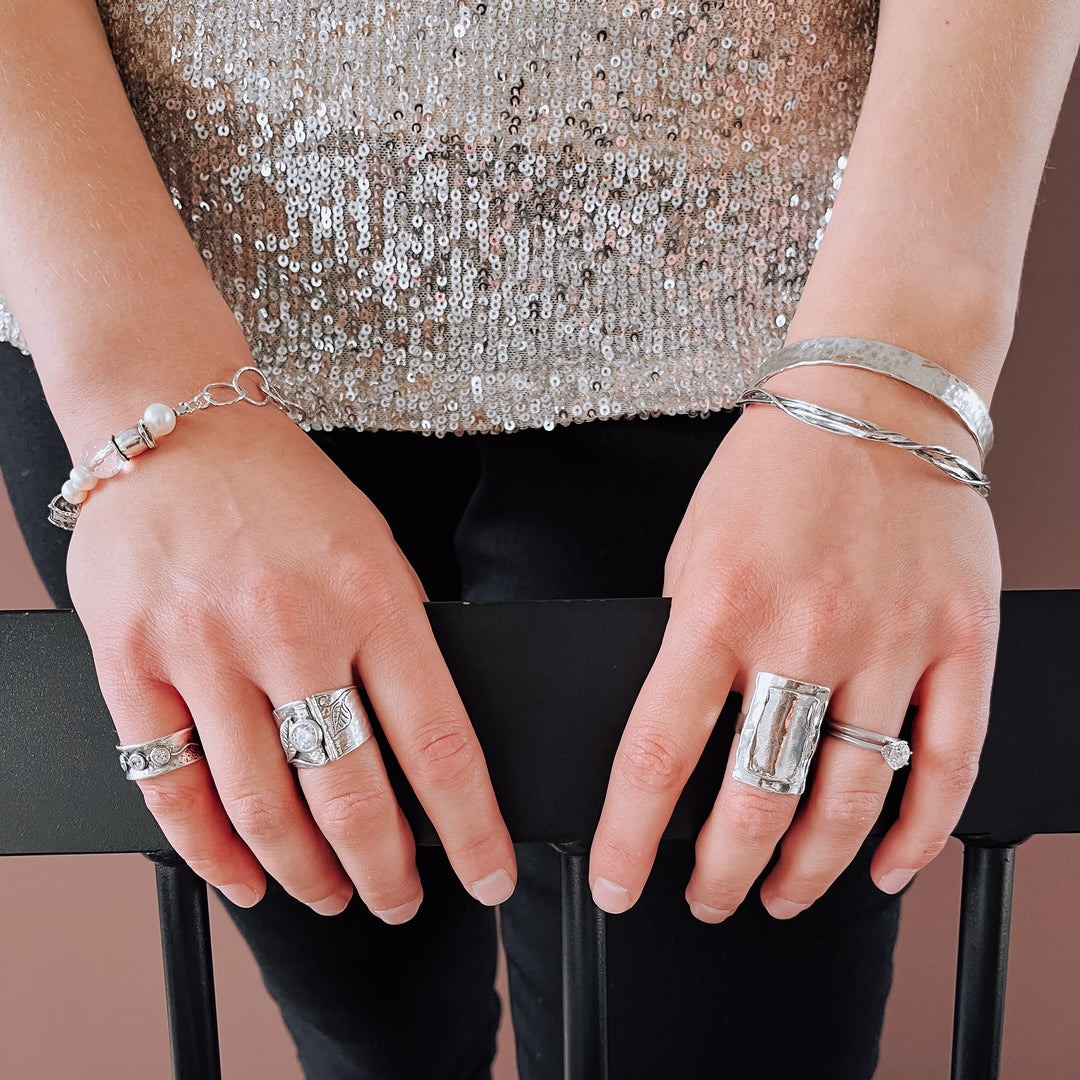 A sterling silver ring with a layered rectangle design is shown on a model. 