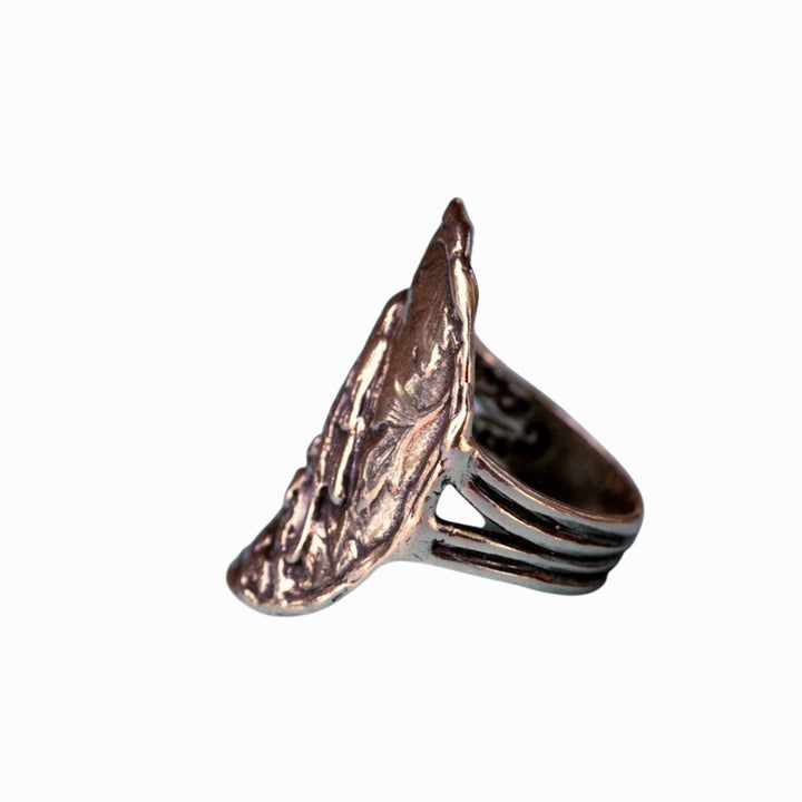 A sterling silver ring with a detailed bird design perched on a branch, showing slight oxidation, is shown from the side on a white background.