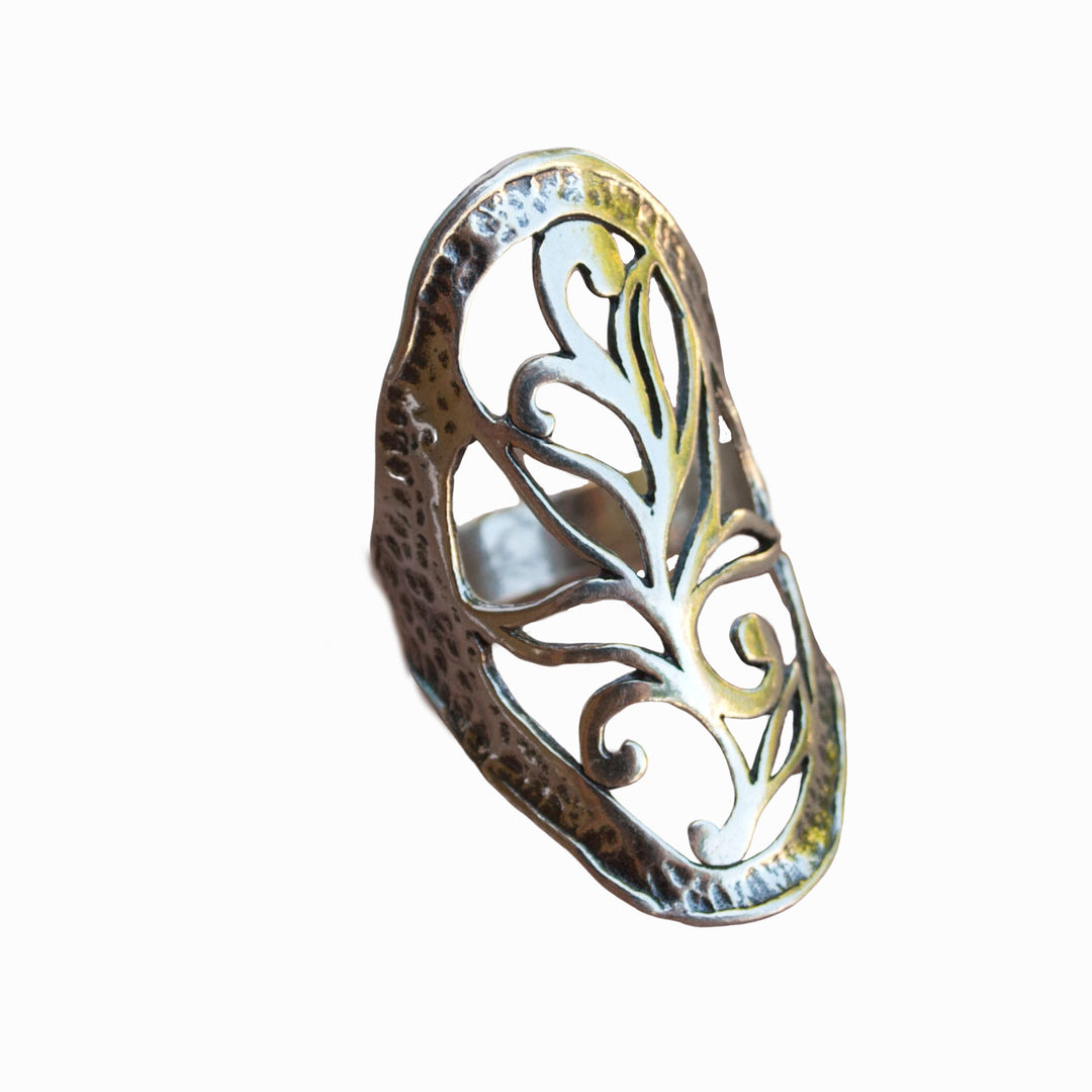 A sterling silver ring with intricate open scroll work, slightly oxidized for depth and detail, is shown from the side on a white background. 