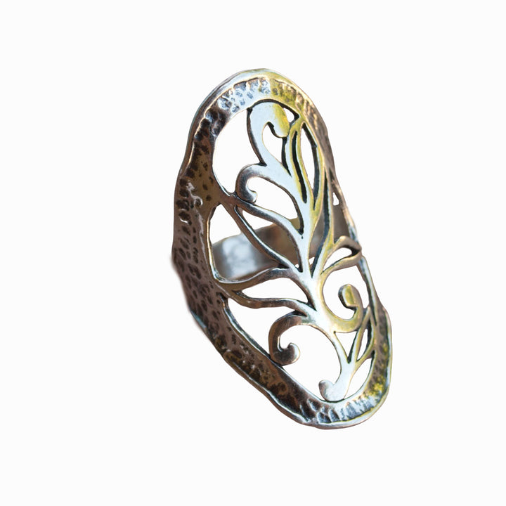 A sterling silver ring with intricate open scroll work, slightly oxidized for depth and detail, is shown from the side on a white background. 