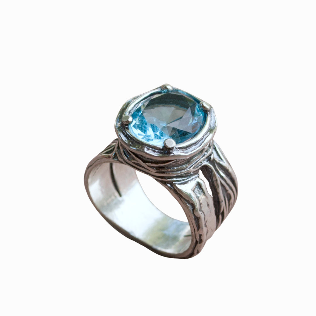 Silver Ring - artisan-crafted in .925 sterling silver with a faceted blue topaz, shown on a white background. 